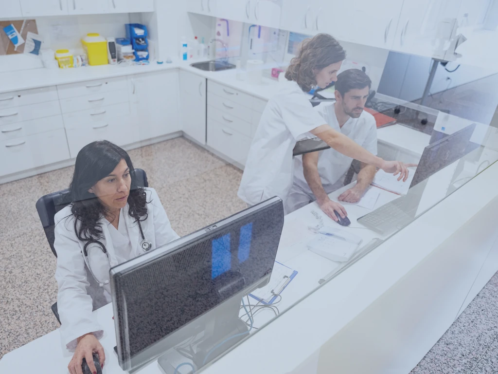 Chancen für Krankenhäuser durch New Work Zwei Ärztinnen und ein Arzt arbeiten im Ärztezimmer im Krankenhaus im Patientenportal.