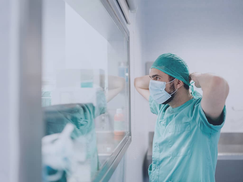 Die Expertise spezialisierter Portalanbieter Ein Arzt bindet sich eine Maske um.