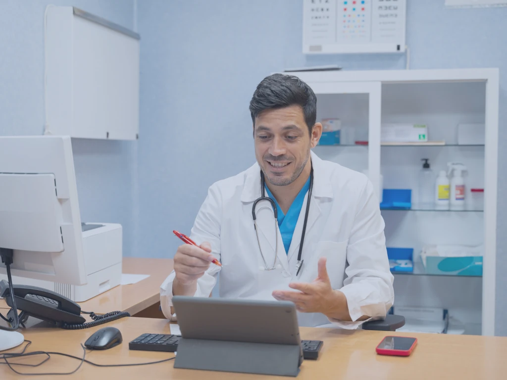 Ein Mediziner spricht in einer Videokonferenz in sein Pad