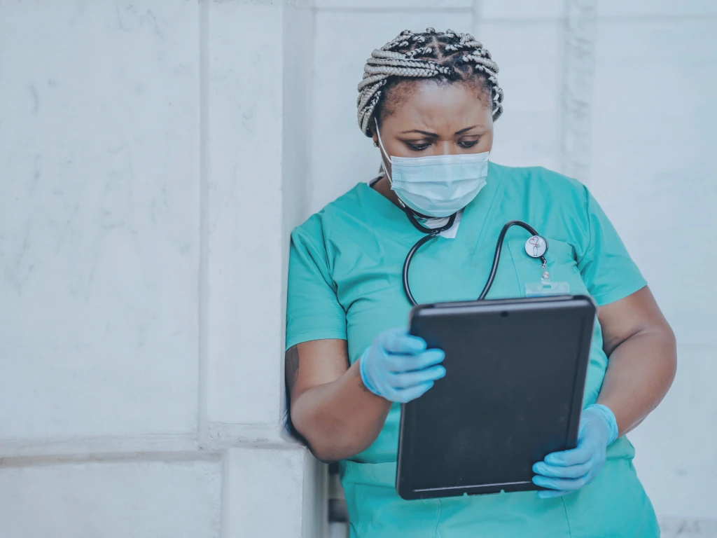 Eine Ärztin nutzt KI Funktionalitäten auf einem mobilen Device.