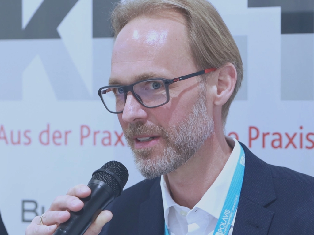 Dr. Manuel Iserloh spricht auf der KH IT-Presserunde auf der DMEA. Er hält ein Mikrofon in der Hand.