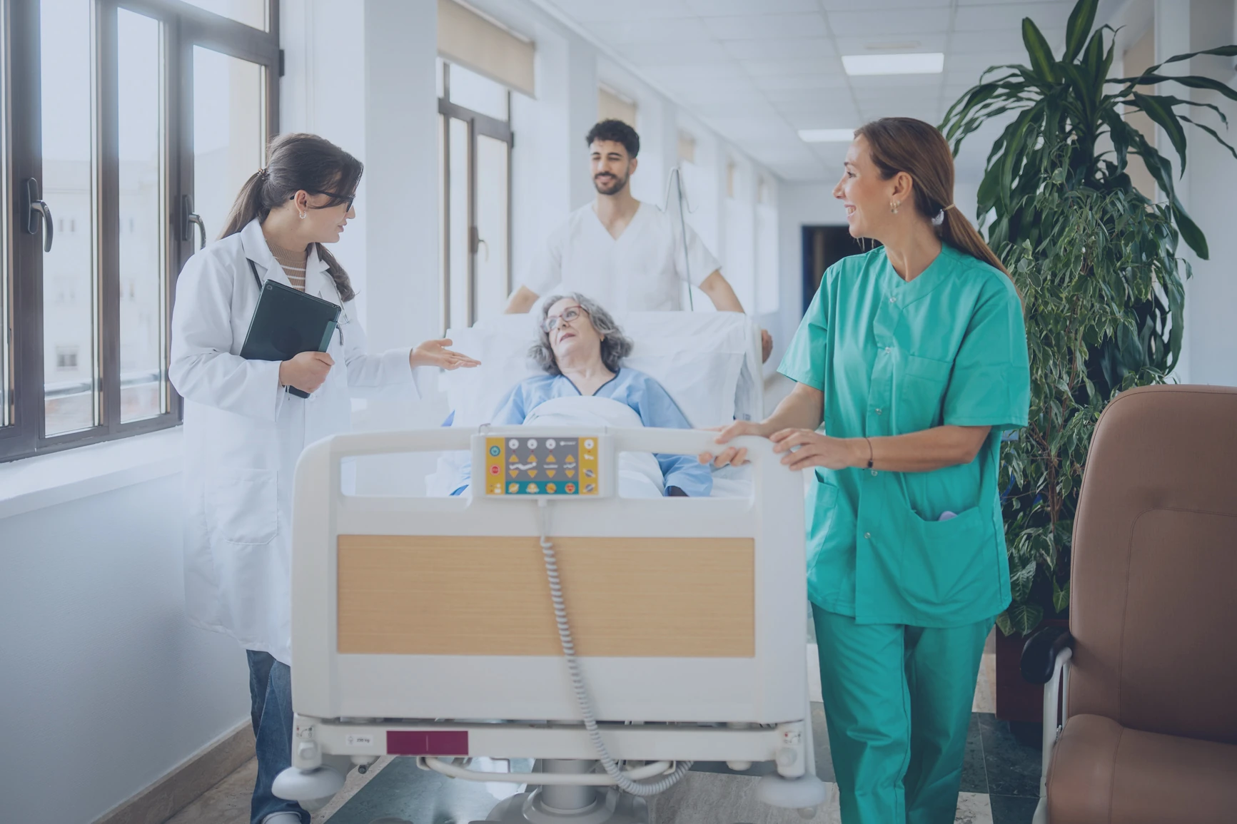 Eine internationale Patientin im Krankenbett wird von mehreren Fachkräften geschoben.