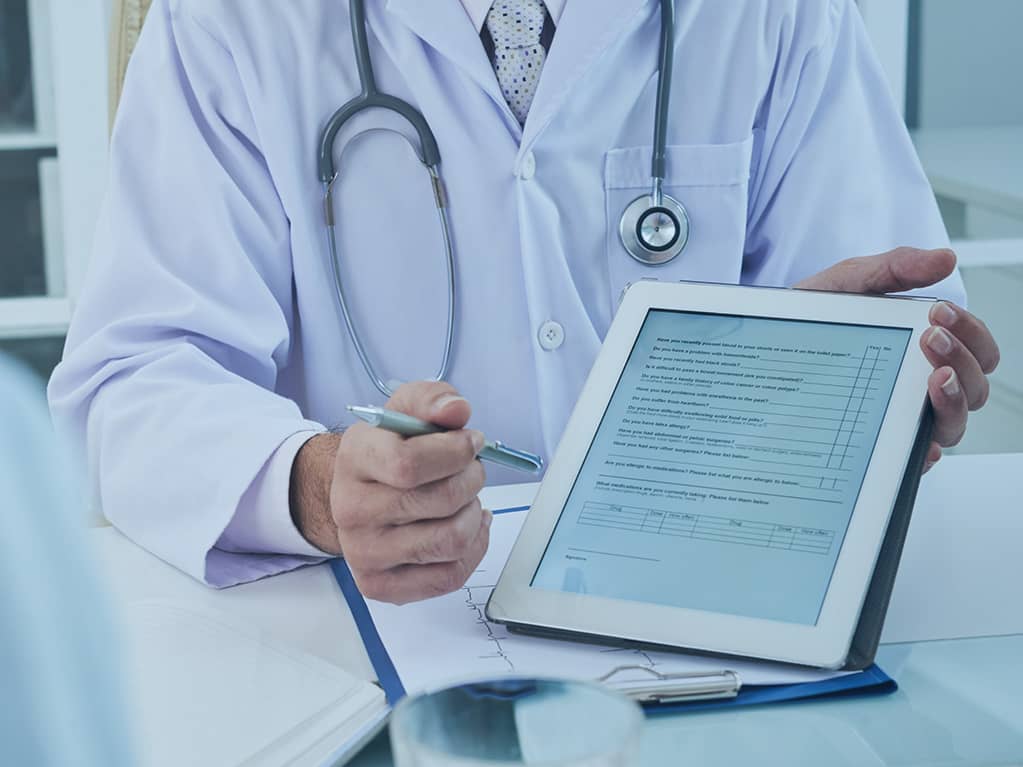 Ein Arzt bietet ein elektronisches Dokument zur Unterschrift.