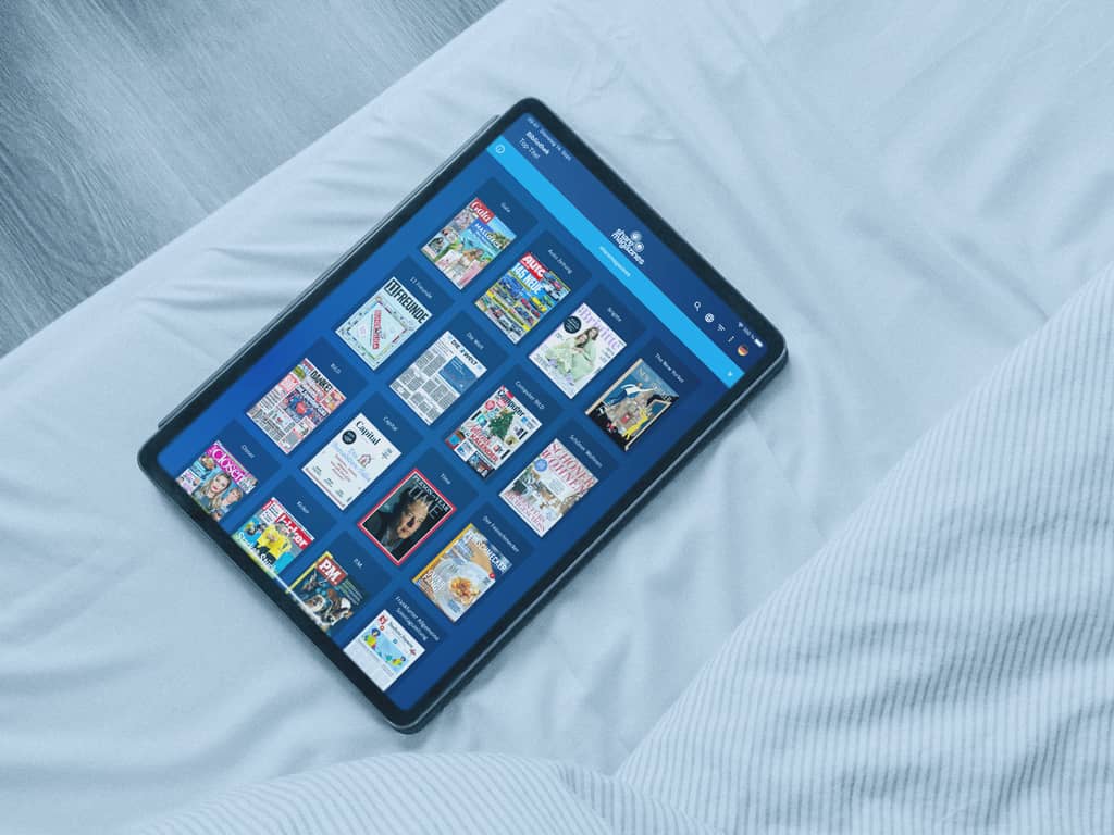 Auf einem Klinikbett liegt ein Pad, auf dem die sharemagazines Webseite zu sehen ist.