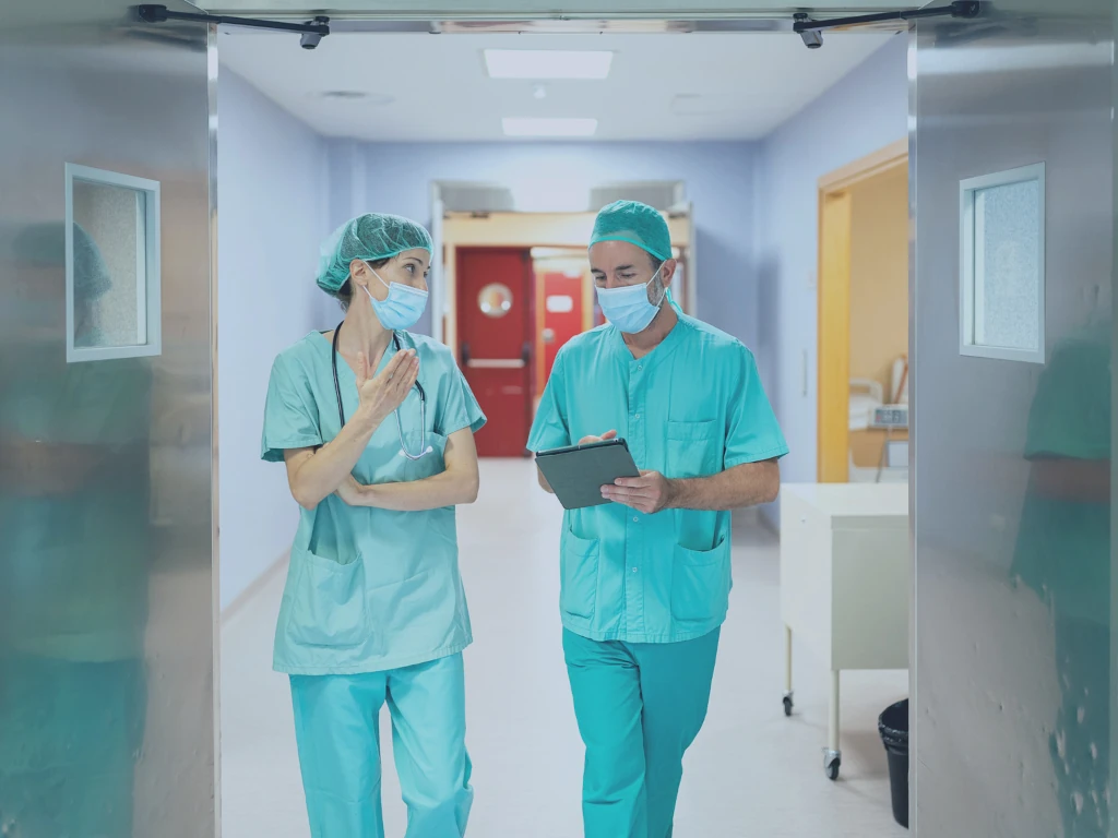 Eine Ärztin und ein Arzt im Gespräch, sie nutzen das POLAVIS Patientenportal.