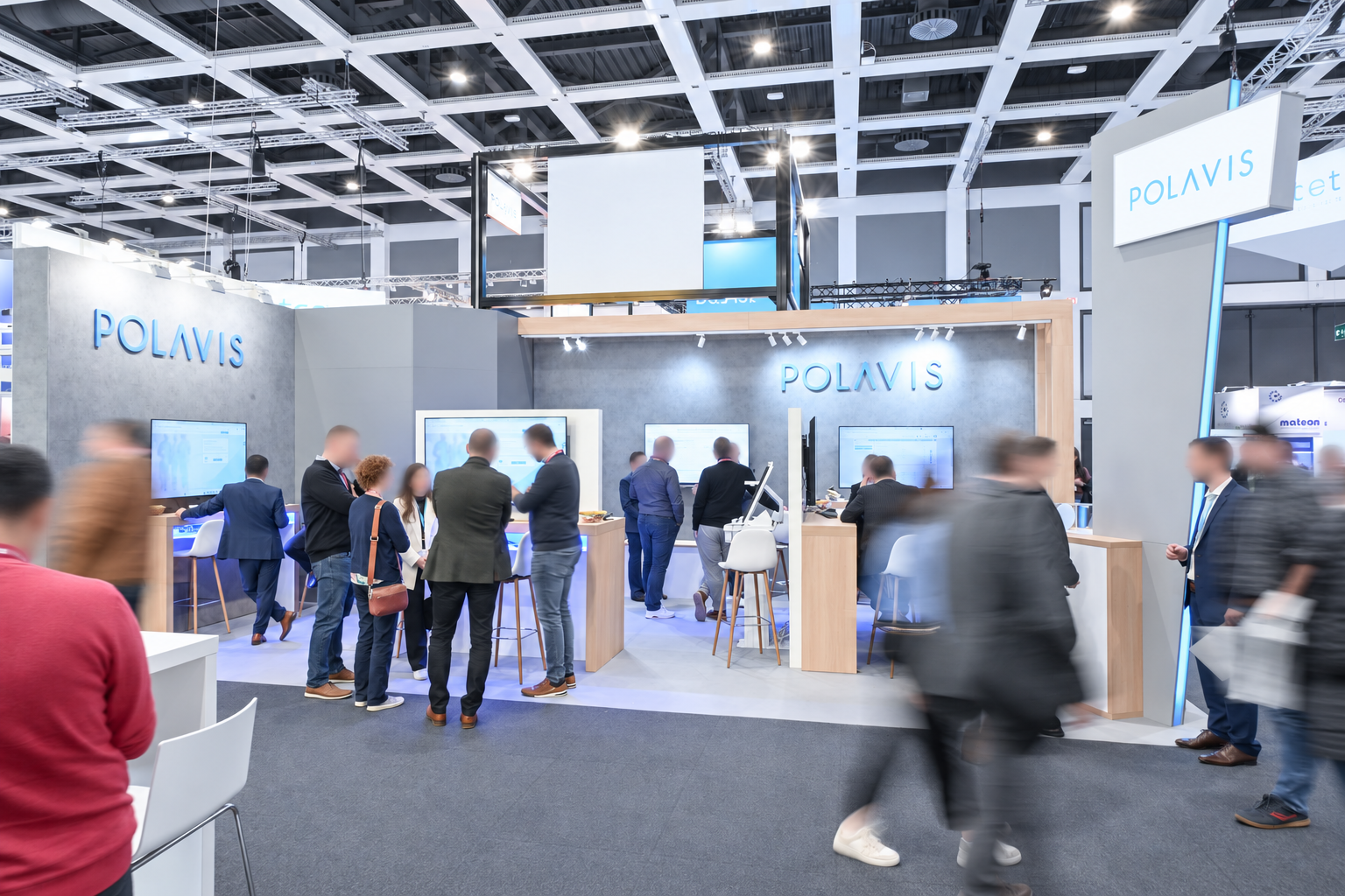 Besucher im Gespräch am Messestand von POLAVIS, Gesichter dezent weichgezeichnet